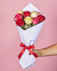 9 mixed colour roses and baby's breath wrapped in white tissue paper with a red ribbon.